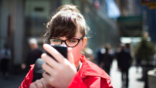 woman-using-smartphone-street-getty-images